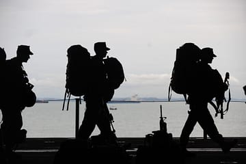military persons and veterans walking with gear
